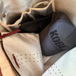 Gray hat with 'Kobe' branding inside a silver bag.
