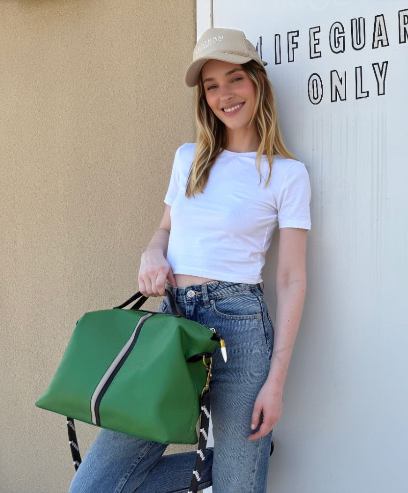 Woman holding a green bag in front of a 'Lifeguards Only' door.