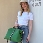 Woman holding a green bag in front of a 'Lifeguards Only' door.